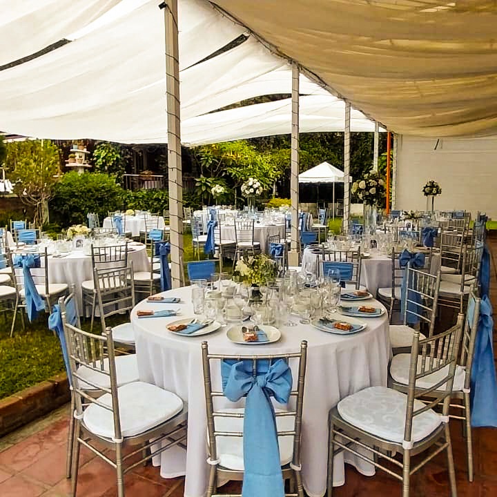 Montaje de evento con sillas Chiavari y moños azules